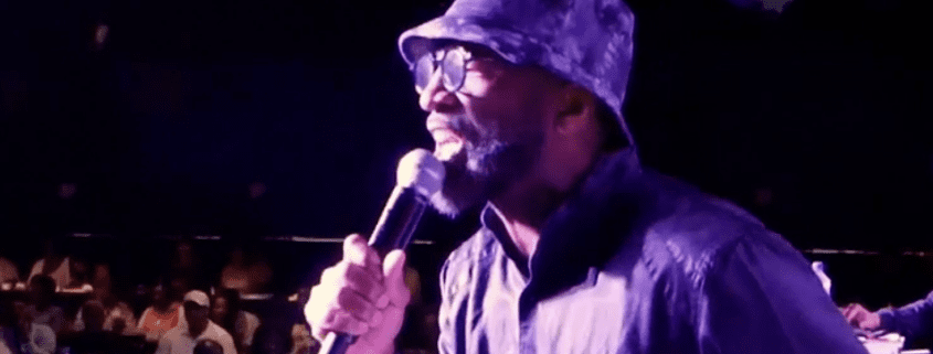 Singer performing with microphone on stage.